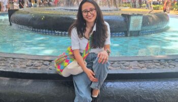 Woman sitting on edge of fountain