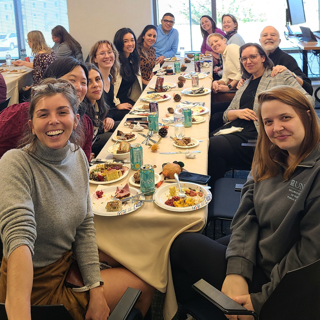 Group of people eating around a table in a conference room