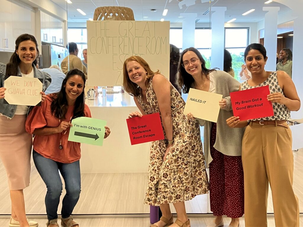 Five women in a group photo holding signs